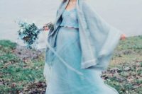 16 the bride wearing an ice blue separate with a lace crop top, a layered tulle skirt, a comfy coverup and an icy blue bouquet