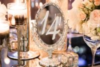 17 a glam winter wedding tablescape with candles, sparkling chargers and mirror table numbers