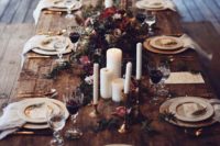 17 a rustic boho winter wedding tablescape with candles, dark florals and foliage and refined plates and cutlery