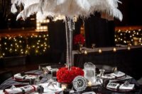18 a black, red and whiet tablescape with a feather centerpiece, red roses and chargers and black and white settings