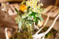 20 a woodland wedding centerpiece with moss, antlers and yellow blooms is great for the fall