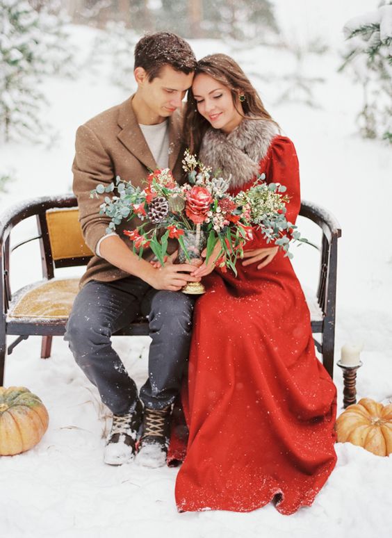 vintage-inspired red wedding dress with long sleeves anda faux fur scarf on top to feel warm