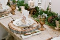 21 an elegant rustic table setting with an evergreen and pinecone garland, candles, wood slices and cinnamon sticks