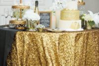 22 a glam dessert table with a gold sequin tablecloth, gold stands and a white and gold wedding cake