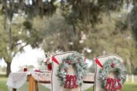 22 evergreen wreaths with red ornaments and red ribbons on the chairs for decor