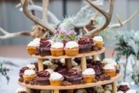 23 a creative rustic cupcake display with lots of antlers for a woodland feel