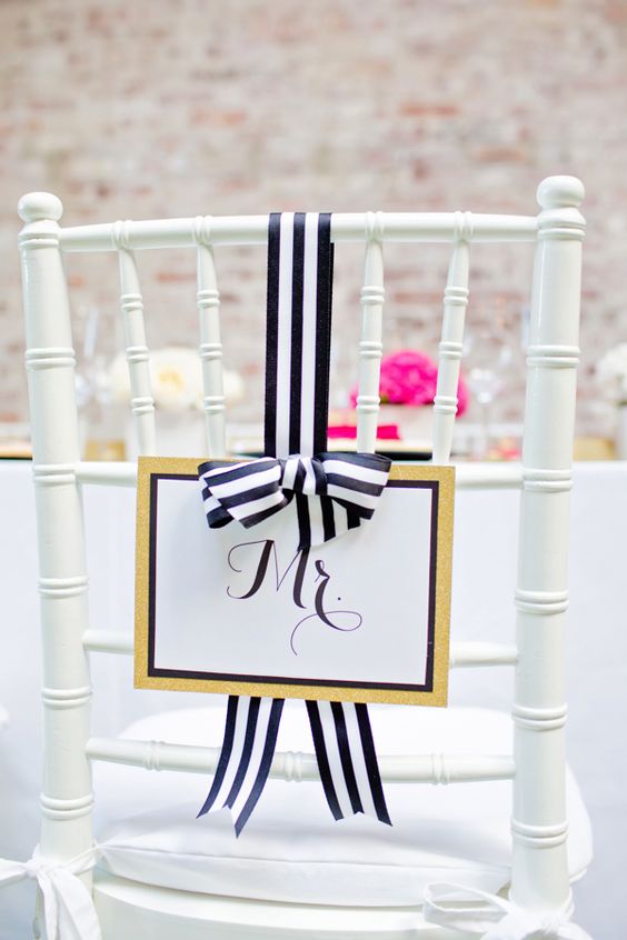 a glam wedding sign with gold glitter, framing and black and white striped bow for a cute wedding