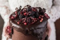 24 a delicious moody wedding cake with chocolate dripping, berries and pomegranate