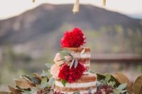 25 a naked wedding cake with bold red blooms and fresh greenery looks yummy