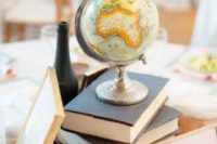 27 a stack of books with a globe on it for a travel-themed wedding