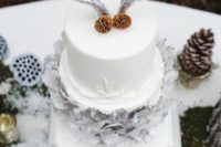 28 a winter wedding cake topped with pinecones and snowy antlers is great for a chic boho wedding