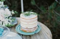30 a semi naked wedding cake on an ice blue plate for a winter wedding