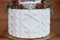 32 a wedding cake with a cable knit layer and a naked top, with pinecones, berries and foliage