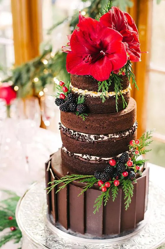 a chocolate Christmas cake with naked tiers, fresh berries, greenery and bold red poinsettias on top is a lovely idea