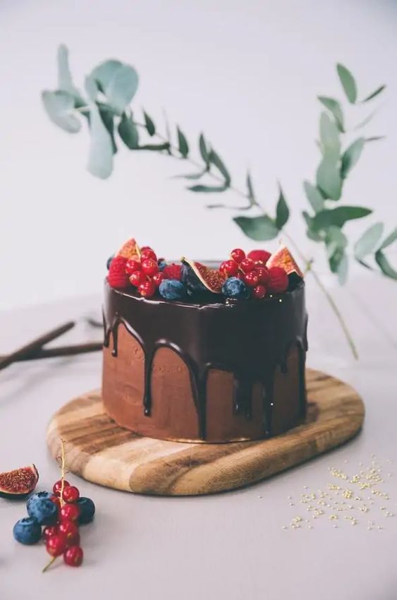 a chocolate wedding cake with chocolate drip, fresh berries on top is always a perfect idea fro any wedding