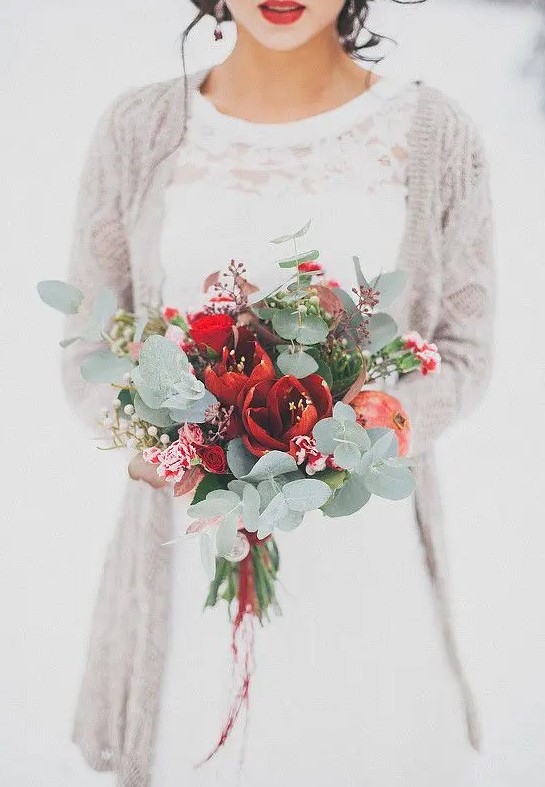 a tender bouquet with red blooms, pomegranate, eucalyptus and dark foliage for a Christmas wedding