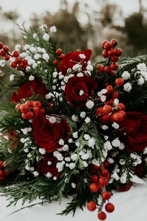 a timeless winter wedding bouquet of ferns, baby's breath, red roses and berries is a very bold idea