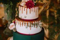 a woodland Christmas wedding cake in white, hunter green and orange, with drip and fresh blooms looks very unusual and modern