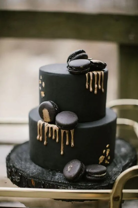 an ultra-modern black wedding cake with gold rip, black and gold macarons is a chic and cool idea for a modern moody wedding