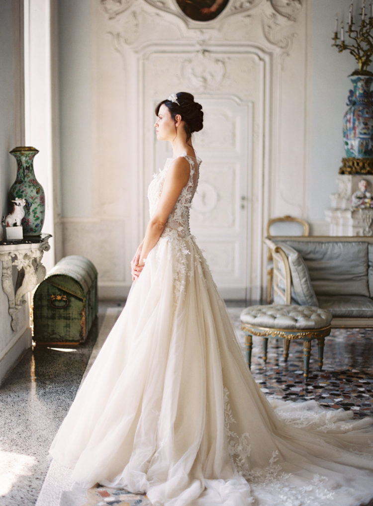 The bride was wearing a beautiful lace applique wedding dress with a train and an illusion neckline