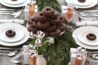 02 an ultimate tablescape with a fresh greenery runner, silver trees, chocolate donuts to make each place setting