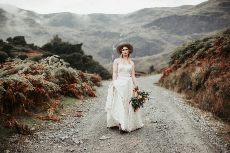 the first bridal look was done with a boho lace strapless wedidng dress, twisted braids, boots and a hat