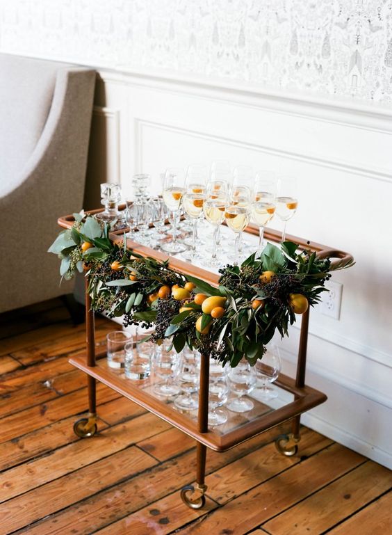 a decorated champagne cart - greenery and fresh citrus to make it chic