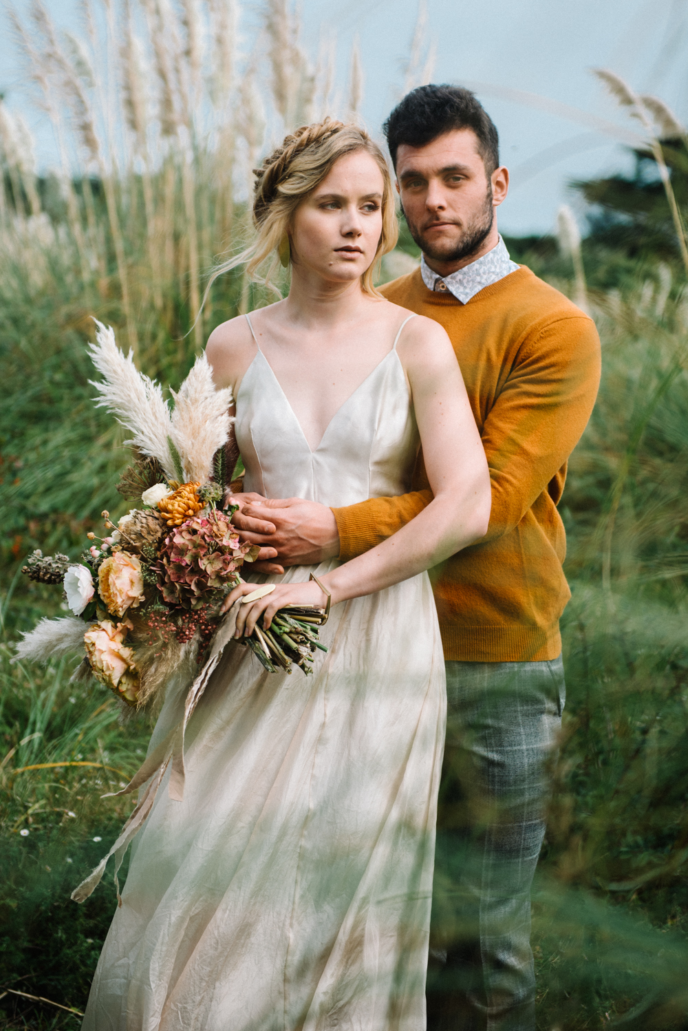 The bride was wearing a spaghetti strap silk wedding dress, the groom was wearing a mustard sweater and grey printed pants