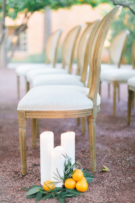 line up your wedding aisle with pillar candles, foliage and citrus to make it look chic