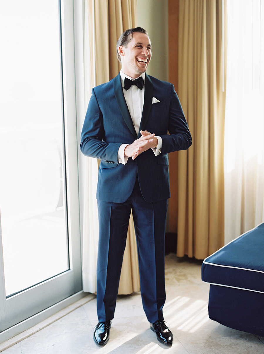 The groom was wearing a navy tuxedo with black lapels and black shoes