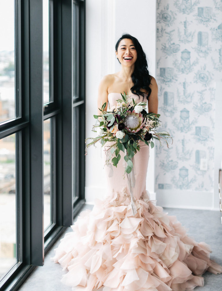a blush strapless mermaid wedding dress with a ruffled tail