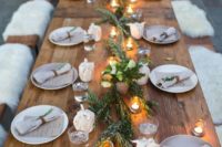 05 a winter tablescape with a fresh greenery runner, candles and faux fur benches