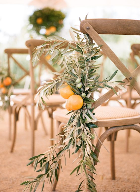 decorate chairs in the ceremony space with olive branches and oranges for a gorgeous look