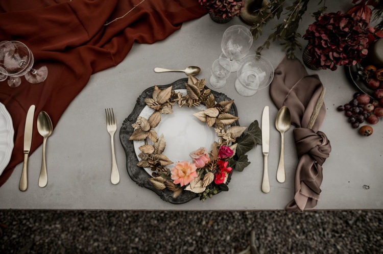 The wedding tablescape was done in moody shades, with fruit and berries and gold touches