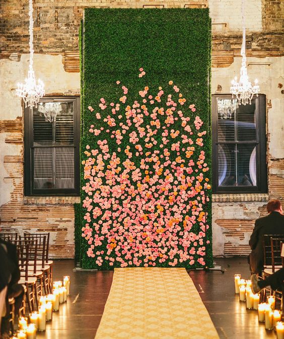 a living wall with real orange and pink blooms and a couple of glam chandeliers completely changes the venue