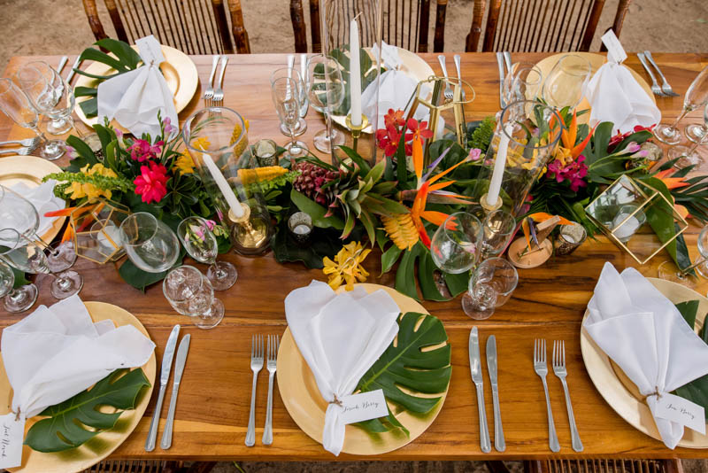 Gilded chargers and tropical leaves added chic to the table