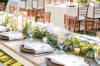 10 The wedding table setting was done with a greenery garland, candles and wicker chargers