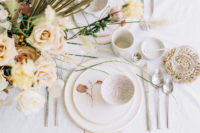 11 The tablescape features unique pottery and blush and neutral blooms
