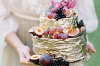11 The wedding cake was a metallic gold one with a texture and topped with fresh fruit and berries