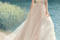 11 a blush cap sleeve wedding dress with a lace applique bodice and a full layered skirt