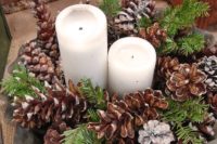 12 a lush centerpiece with snowy pinecones, evergreens and pillar candles