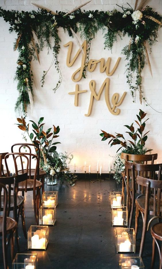 attach calligraphy letters, greenery and blooms right to the white wall to make a cool backdrop