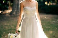 12 ethereal sleeveless wedding dress with a lace applique bodice, a faux sweetheart neckline and a layered skirt