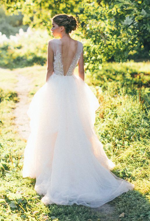 wedding ballgown with an illusion lace applique bodice, a V cut back and a layered skirt