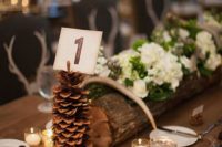 13 a large pinecone table number holder will bring a rustic feel to the table
