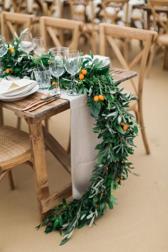 a lush greenery table runner with kumquats is a great idea for a rustic tablescape