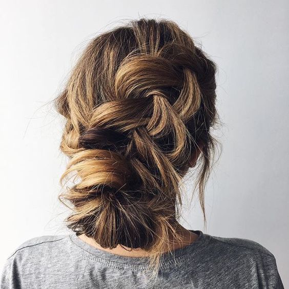 a casual messy braided low updo with bangs is ideal for those brides who don't want much mess