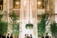 14 an ethereal curtain, lots of greenery around and greenery chandliers completely change the industrial venue