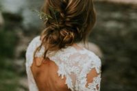 15 a casual braided and twisted low updo with bangs with some greenery in it