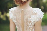 15 a cute feminine wedding dress with lace appliques, draping and a cutout detail on a button